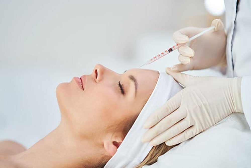 A person undergoing a dermal filler treatment with a relaxed expression, indicating minimal discomfort.